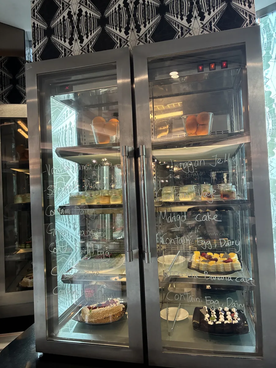 小さなケーキやタルトが並ぶデザートの冷蔵ケース