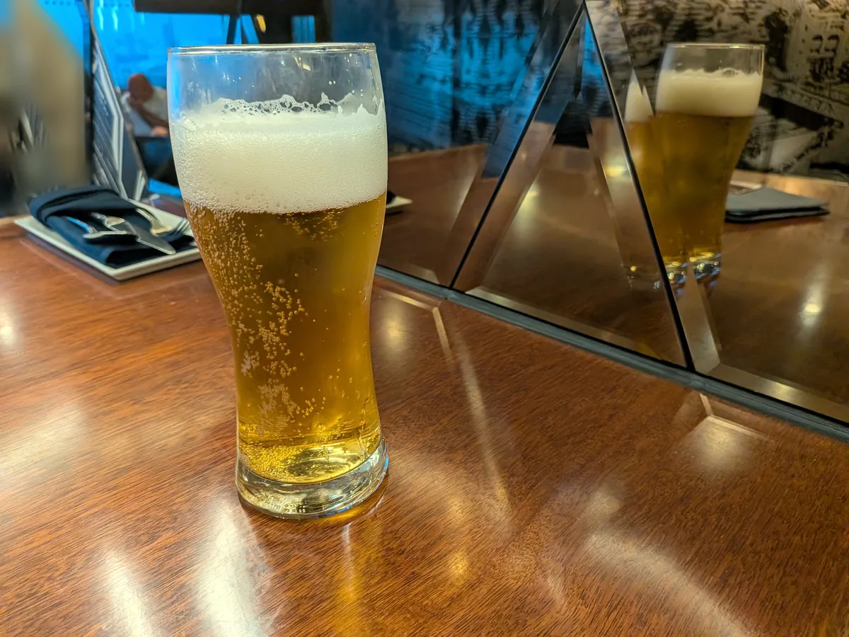 木のカウンターに置かれた注ぎたてのビール
