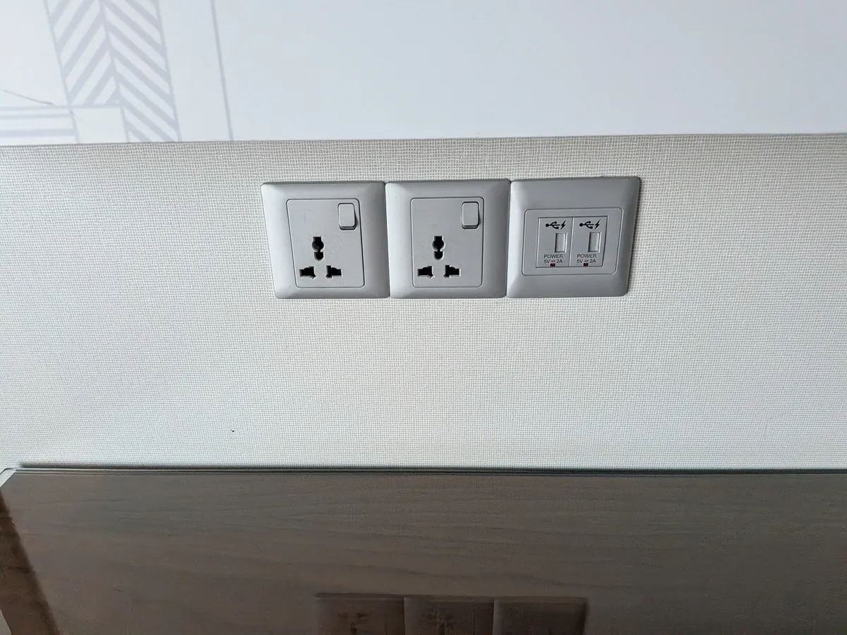 客室の壁に並ぶコンセント3口とUSBポート