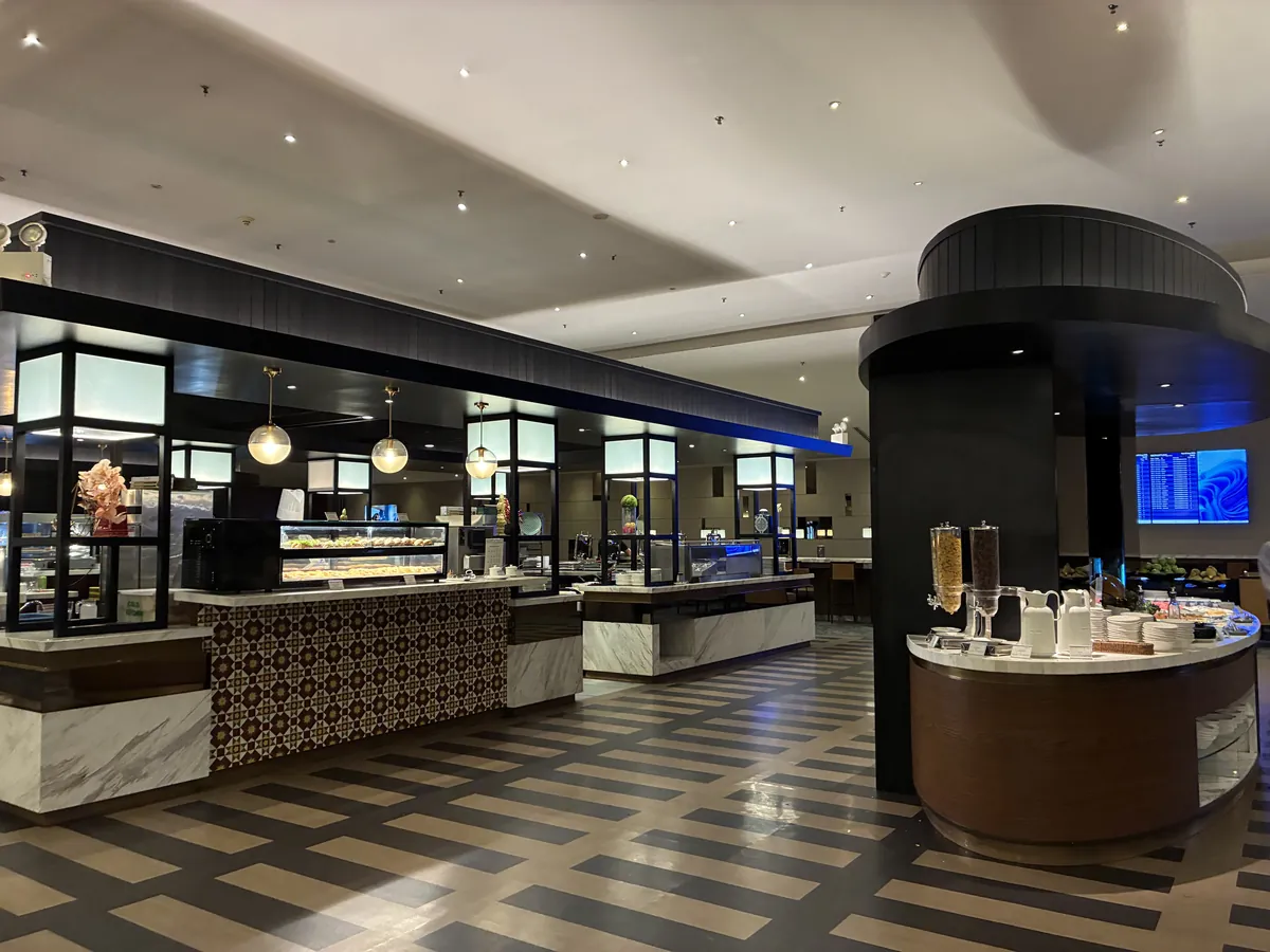 ゴールデンラウンジのダイニングエリア全景。市松模様の床にビュッフェカウンターとショーケースが並び、丸いペンダントライトが下がる