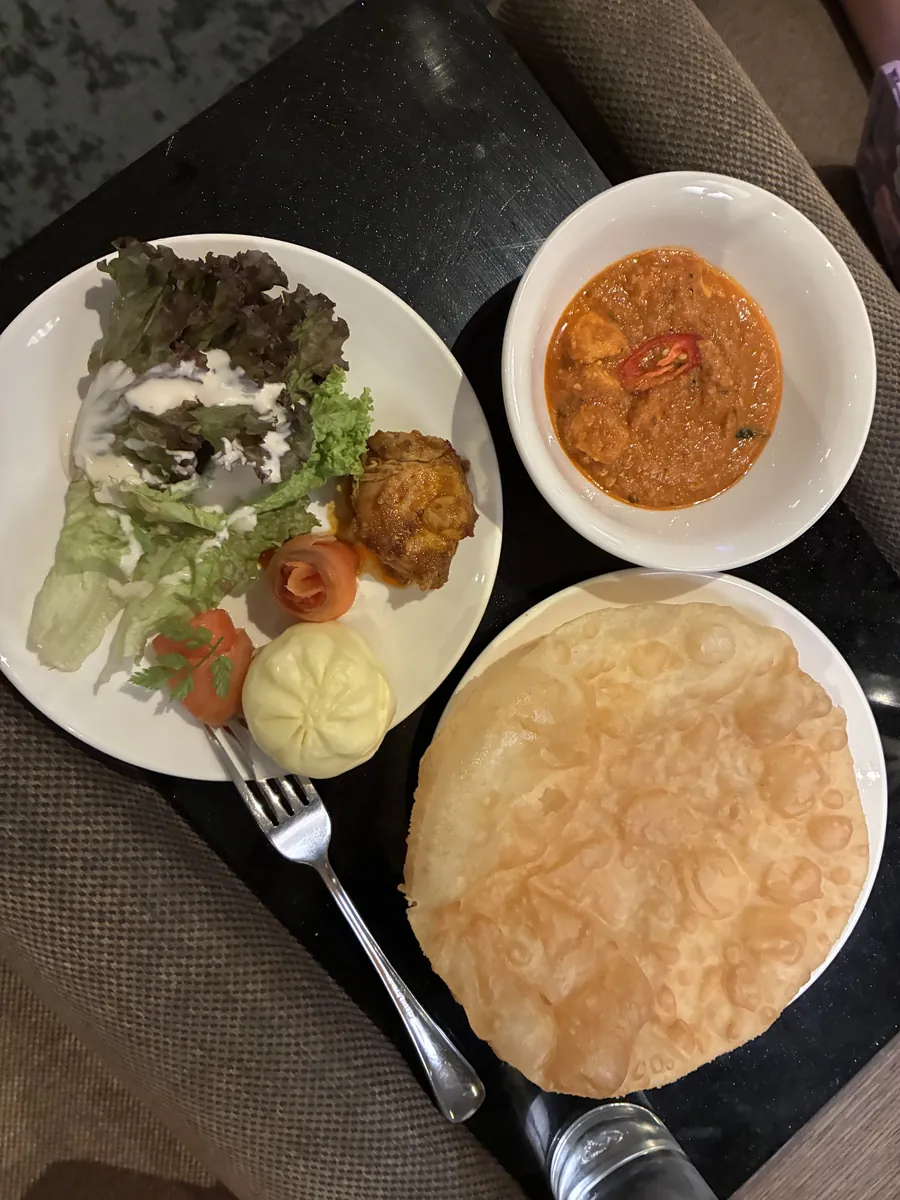 実際に取った1皿目。サラダとチキン、赤いカレー、そして大きな揚げたてのロティ