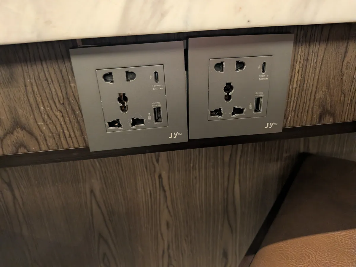 カウンター下に設置された複数のプラグ形状に対応するユニバーサル電源コンセントとUSBポート