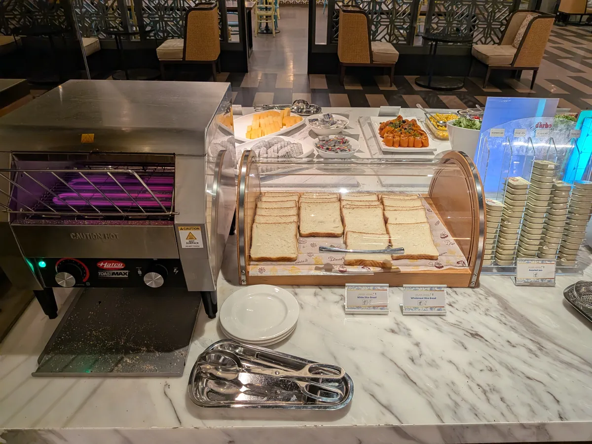 コンベア式のトースターと食パンのケース。奥にはチーズやコールドカットのコーナーが続く