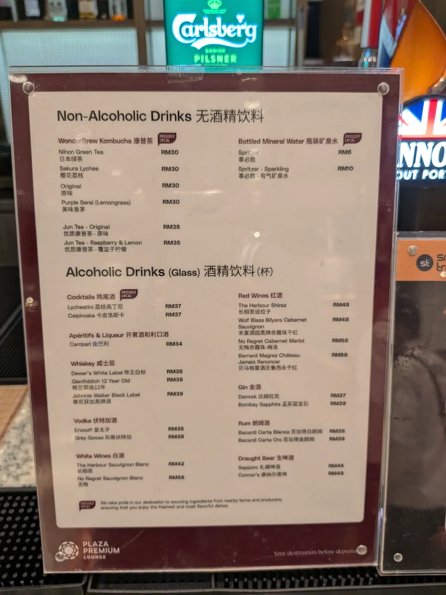 バーカウンターに置かれた有料ドリンクメニュー。生ビールのサッポロRM45、Connor's RM48をはじめ、ワイン・カクテル・ウイスキーの価格が記載されている