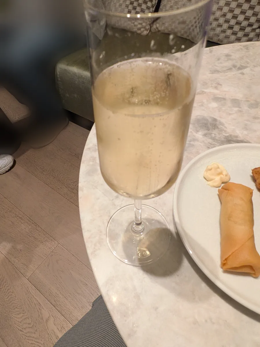 スパークリングワインのグラスとスプリングロールを乗せた皿
