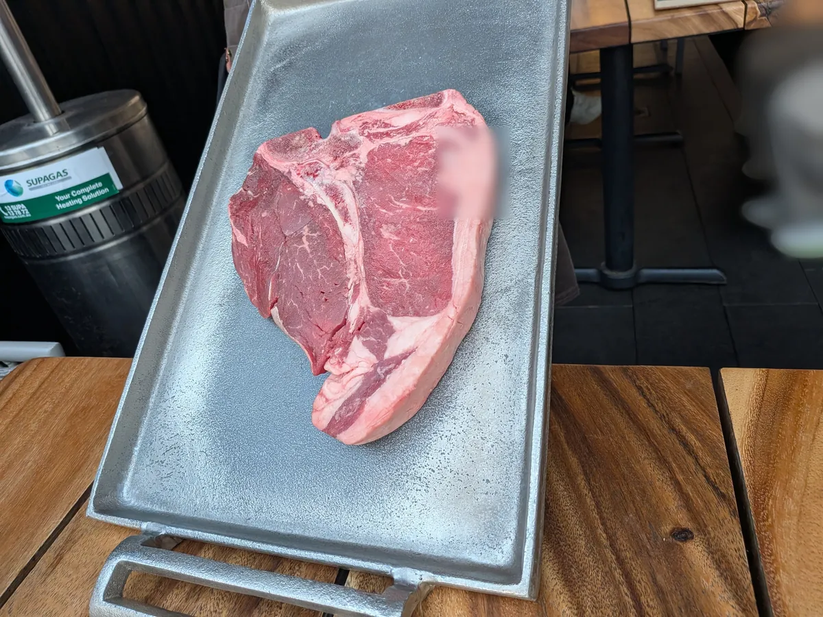 焼く前のTボーンステーキ。骨をはさんでサーロインとフィレが並ぶ生肉が金属のトレーに載せられている