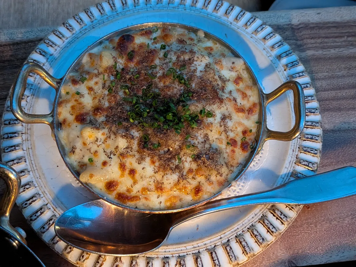 トリュフのマカロニ&チーズ。チーズがこんがり焼けた表面にパン粉とチャイブが散らしてある