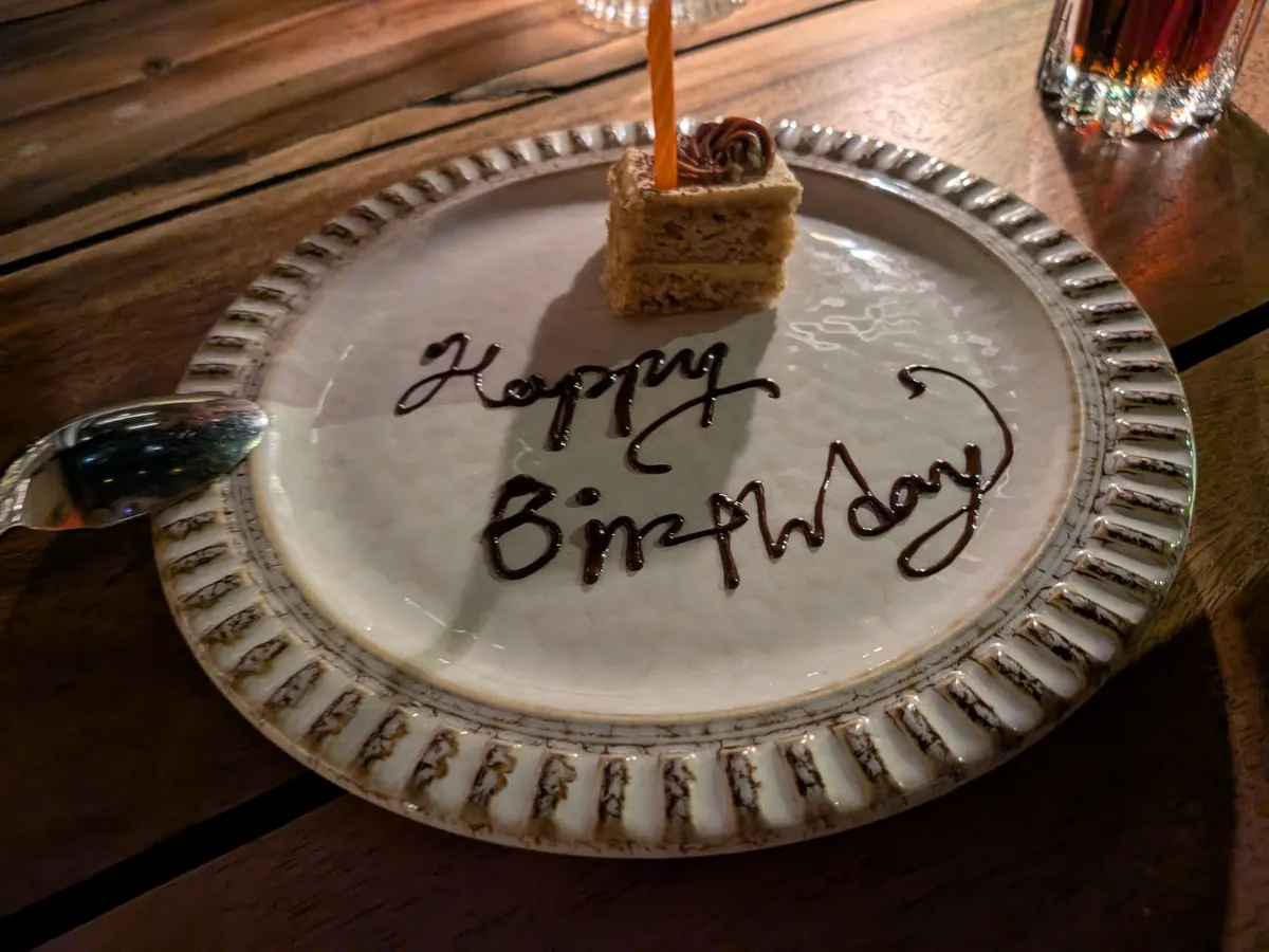 ろうそくを立てたカップケーキと、チョコレートでHappy Birthdayと書かれた皿