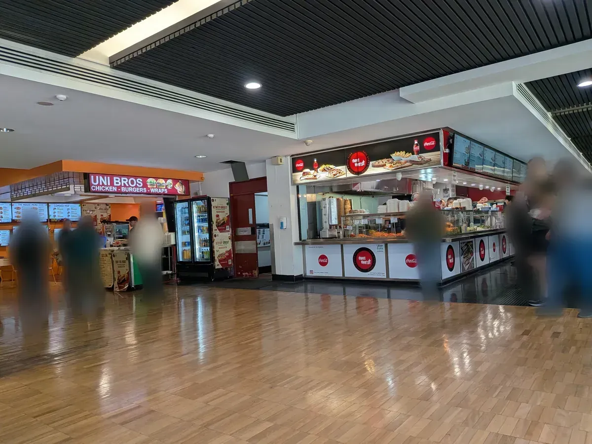 ウェントワース棟のフードコート内部。寄木張りの床の広いホールに、UNI BROSなど複数の専門店のカウンターが並んでいる