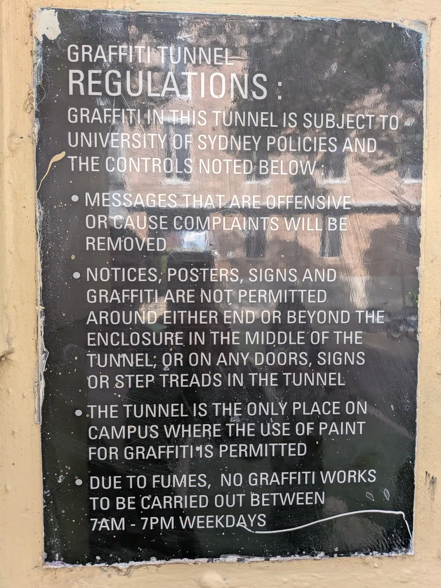 グラフィティトンネルの規約看板。GRAFFITI TUNNEL REGULATIONS の見出しの下に、撤去の条件や描いてよい範囲、平日7時から19時は作業禁止などが英語で書かれている