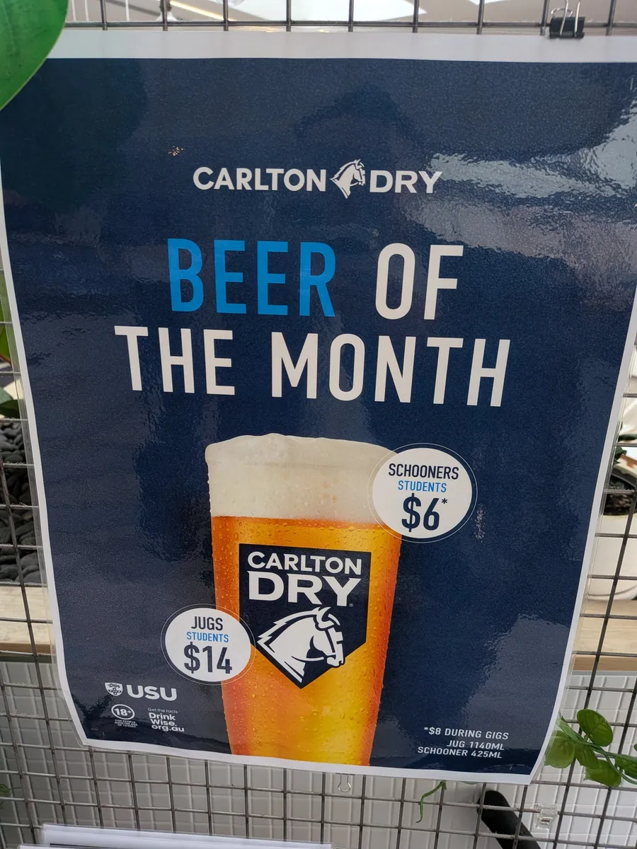CARLTON DRYのBEER OF THE MONTHのポスター。学生価格でスクーナー6豪ドル、ジャグ14豪ドルと書かれ、下にJUG 1140ML・SCHOONER 425MLの注記がある