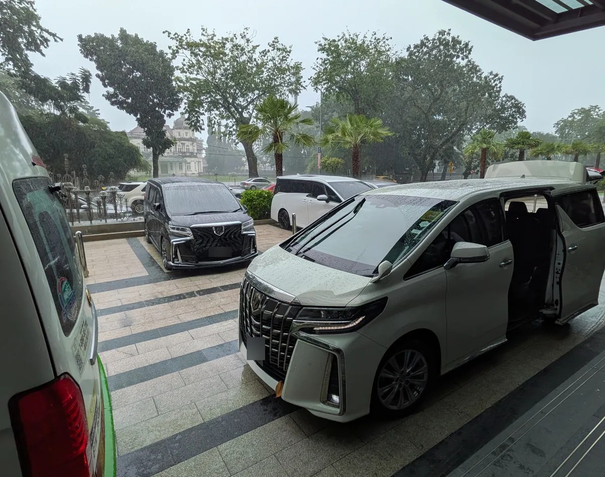 雨のホテル車寄せに停まる白いトヨタ・アルファード。グラブのExecで空港からジョージタウンまで送迎してもらった車