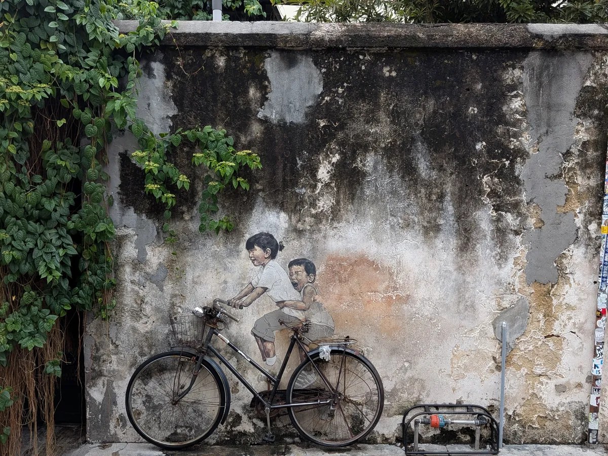ペナンで最も有名な壁画Kids on Bicycle。古びた壁に描かれた姉弟と壁に据え付けられた本物の自転車