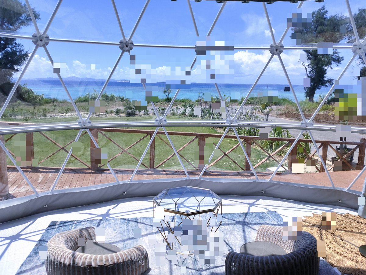 沖縄のグランピング施設、ドームテント内から望む青い海と空