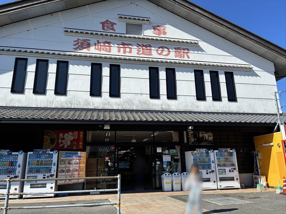 白い建物に赤い文字で「食事」「須崎市道の駅」と書かれた施設の外観。入り口前には複数の自動販売機が設置されている。