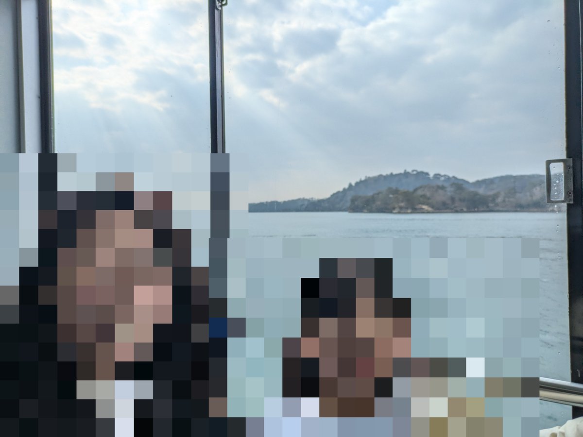 松島湾遊覧船の窓から外の景色を背景に笑顔で座るマイとメイ