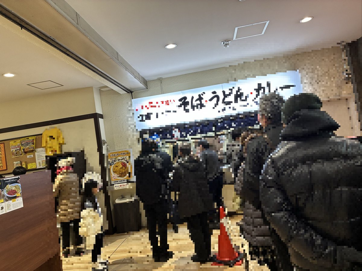 万代シテイバスセンターの立喰いコーナー。朝から行列が絶えない人気店。そば・うどん・カレーの看板が見える。