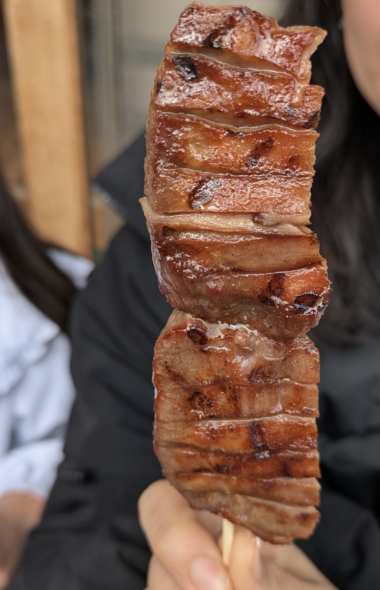 松島の牛タン串を手に持つ — 肉厚で香ばしい利久の名物