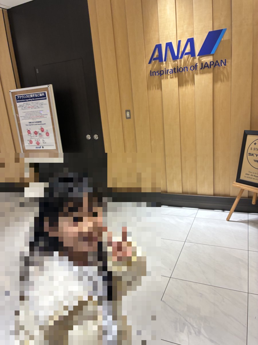 ANAラウンジの入り口で笑顔でピースサインをするメイ