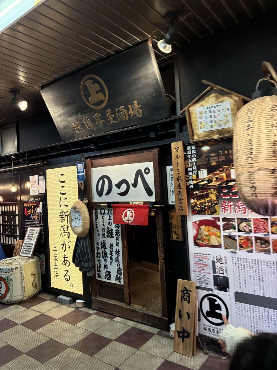 越後番屋酒場の店入口。「ここに新潟がある。」の看板と「のっぺ」の文字が目を引く、風情ある居酒屋の外観。