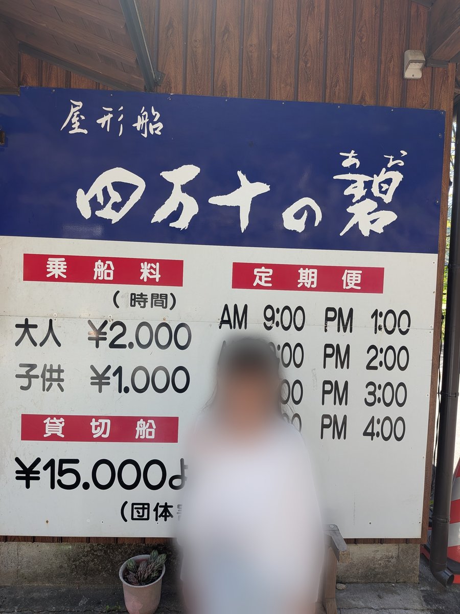 「屋形船 四万十の碧」と書かれた料金表の看板。乗船料や定期便の時間が詳細に記載されている。