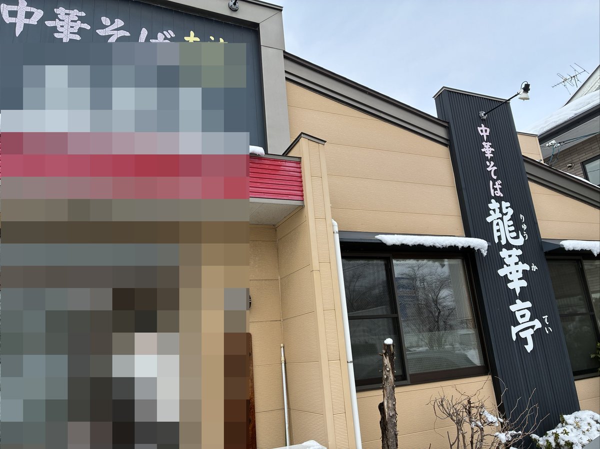 雪景色の中に立つ龍華亭の外観。中華そば専門店の看板が見える。